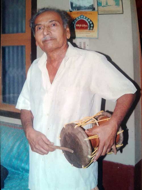 Dr. Puninchathaya playing folk instrument 'Dudi'.