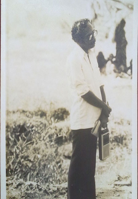 Mr. Puninchathaya recording Pardana(tulu folk songs) in his tape-recorder in a village.